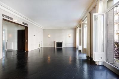 Salle à manger élégante avec table noire ornée, chandeliers, sculpture de panthère et tableau coloré au mur.