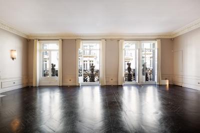 Salle à manger élégante avec table noire ornée, chandeliers, sculpture de panthère et tableau coloré au mur.