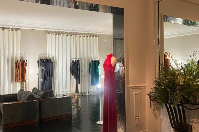Salle à manger élégante avec table noire ornée, chandeliers, sculpture de panthère et tableau coloré au mur.