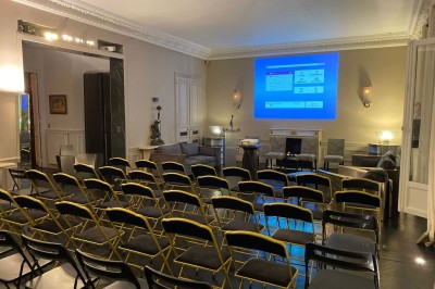 Salle à manger élégante avec table noire ornée, chandeliers, sculpture de panthère et tableau coloré au mur.