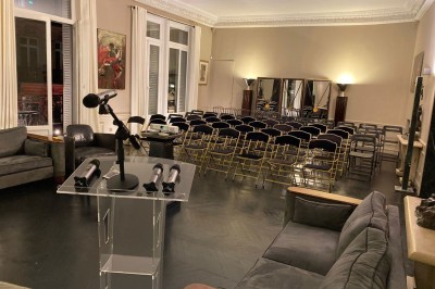 Salle à manger élégante avec table noire ornée, chandeliers, sculpture de panthère et tableau coloré au mur.