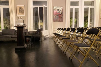 Salle à manger élégante avec table noire ornée, chandeliers, sculpture de panthère et tableau coloré au mur.