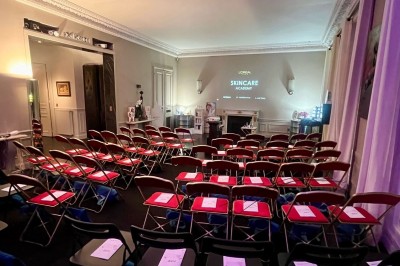 Salle à manger élégante avec table noire ornée, chandeliers, sculpture de panthère et tableau coloré au mur.