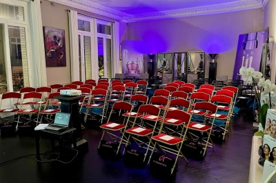 Salle à manger élégante avec table noire ornée, chandeliers, sculpture de panthère et tableau coloré au mur.