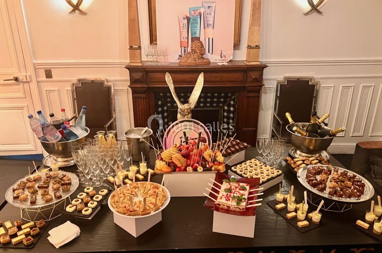 Buffet de desserts variés avec verrines, pâtisseries et boissons, présenté sur une table dans une salle élégante.