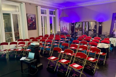 Salle à manger élégante avec table noire ornée, chandeliers, sculpture de panthère et tableau coloré au mur.
