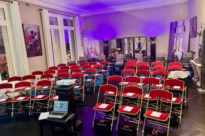 Salle à manger élégante avec table noire ornée, chandeliers, sculpture de panthère et tableau coloré au mur.