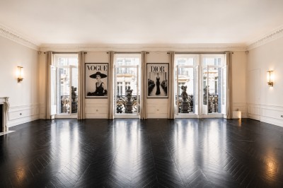 Miniature Location salle Paris 8 (Paris) - Le Loft Triangle d'Or Champs-Élysées #37 Un homme et une femme marchent dans un couloir élégant avec des colonnes blanches et de grands vases rouges.
