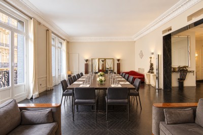 Miniature Location salle Paris 8 (Paris) - Le Loft Triangle d'Or Champs-Élysées #38 Un homme et une femme marchent dans un couloir élégant avec des colonnes blanches et de grands vases rouges.