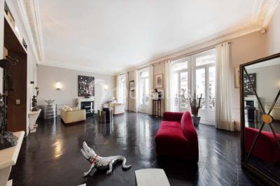 Salle à manger élégante avec table noire ornée, chandeliers, sculpture de panthère et tableau coloré au mur.