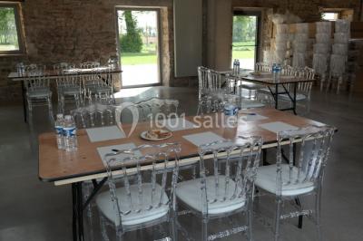 Vue aérienne d'une campagne avec des champs, des arbres, des maisons et des routes annotées pour indiquer des directions.