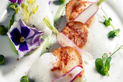 Table de réception élégamment dressée avec menu, verres, et centre de table floral composé de roses rouges et blanches.