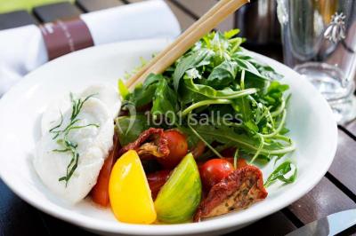 Table de réception élégamment dressée avec menu, verres, et centre de table floral composé de roses rouges et blanches.