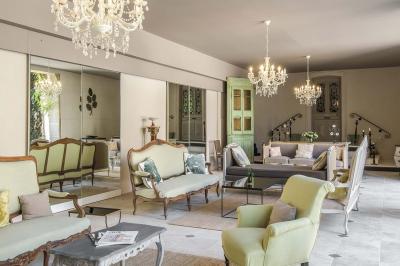 Accueil d'un spa avec comptoir en bois, fauteuils, étagère de produits, et décoration évoquant un arbre.