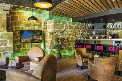 Accueil d'un spa avec comptoir en bois, fauteuils, étagère de produits, et décoration évoquant un arbre.