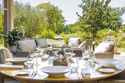 Accueil d'un spa avec comptoir en bois, fauteuils, étagère de produits, et décoration évoquant un arbre.