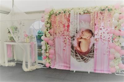Salle de réception décorée en noir et blanc avec tables dressées, chaises blanches et lanternes suspendues.