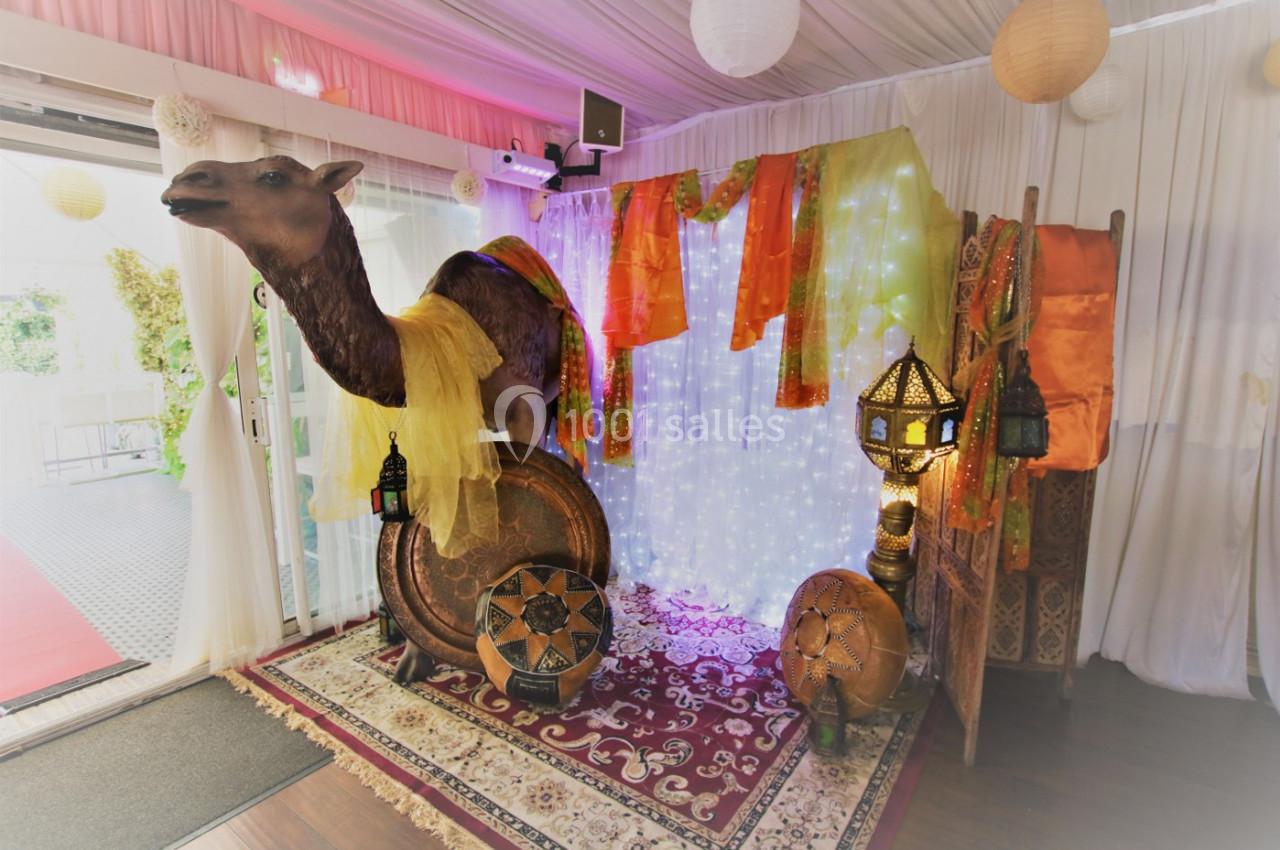 Décoration intérieure sur le thème oriental avec un faux chameau, lanternes, tapis et tissus colorés.