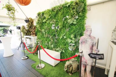 Salle de réception décorée en noir et blanc avec tables dressées, chaises blanches et lanternes suspendues.