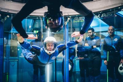 Un groupe de personnes en tenue uniforme observe et interagit avec un écran dans un environnement futuriste.