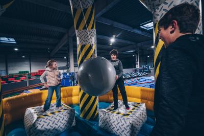 Un groupe de personnes en tenue uniforme observe et interagit avec un écran dans un environnement futuriste.
