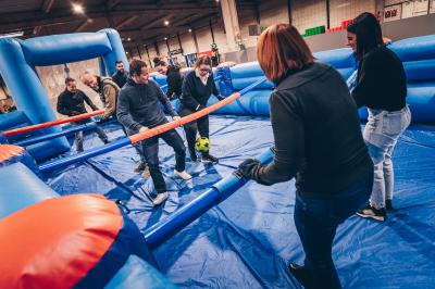 Un groupe de personnes en tenue uniforme observe et interagit avec un écran dans un environnement futuriste.