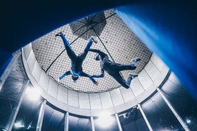 Un groupe de personnes en tenue uniforme observe et interagit avec un écran dans un environnement futuriste.