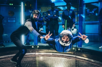 Un groupe de personnes en tenue uniforme observe et interagit avec un écran dans un environnement futuriste.