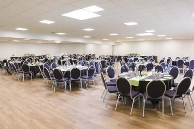 Salle de conférence vide avec des rangées de chaises noires et un écran affichant le logo ’Aerokart’.