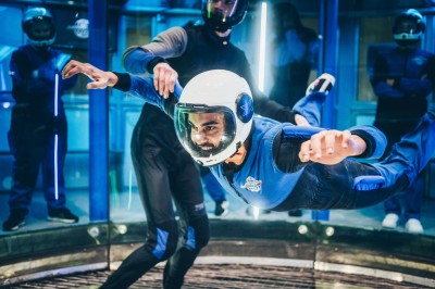 Salle de conférence vide avec des rangées de chaises noires et un écran affichant le logo ’Aerokart’.