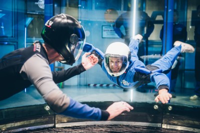Salle de conférence vide avec des rangées de chaises noires et un écran affichant le logo ’Aerokart’.