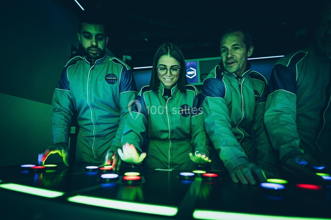 Des personnes en combinaison appuient sur des boutons lumineux dans un environnement sombre et futuriste.