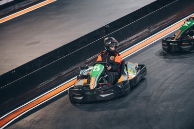 Salle de conférence vide avec des rangées de chaises noires et un écran affichant le logo ’Aerokart’.
