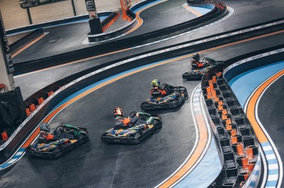 Salle de conférence vide avec des rangées de chaises noires et un écran affichant le logo ’Aerokart’.