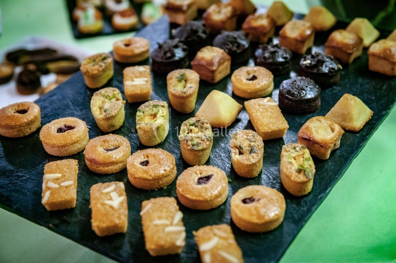 Plateau de pâtisseries orientales variées disposées sur une ardoise noire.