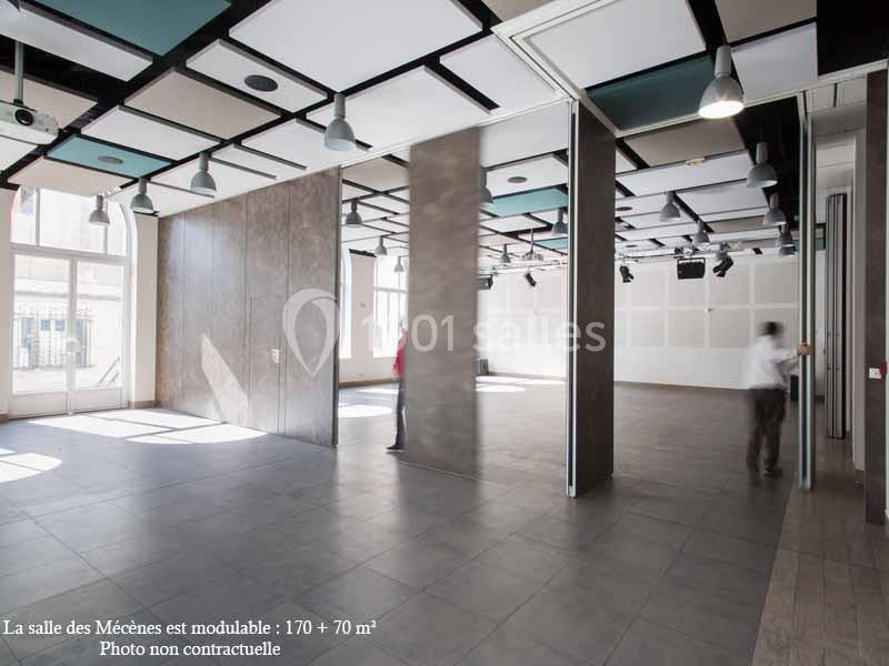 Salle modulable avec cloisons amovibles, sol en carrelage, plafond acoustique et grandes fenêtres laissant entrer la lumière.