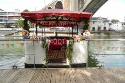 Intérieur élégant avec décorations classiques, horloge, miroir, fleurs et cage décorative dans une lumière tamisée.