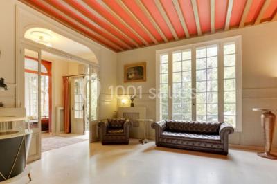 Intérieur élégant avec décorations classiques, horloge, miroir, fleurs et cage décorative dans une lumière tamisée.