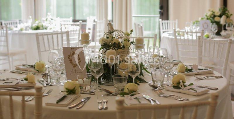 Table de réception élégamment dressée avec des fleurs blanches, des bougies et une décoration raffinée.