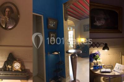 Intérieur élégant avec décorations classiques, horloge, miroir, fleurs et cage décorative dans une lumière tamisée.