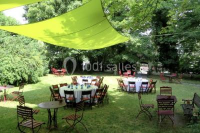 Intérieur élégant avec décorations classiques, horloge, miroir, fleurs et cage décorative dans une lumière tamisée.