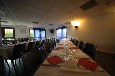 Assiette de carpaccio de bœuf garnie de salade, copeaux de parmesan, tomates et filet de sauce balsamique.
