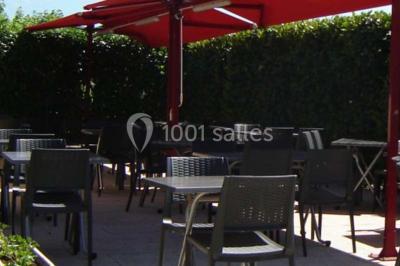 Assiette de carpaccio de bœuf garnie de salade, copeaux de parmesan, tomates et filet de sauce balsamique.