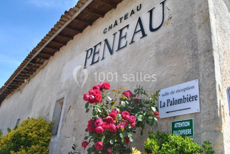 Façade d'un bâtiment avec l'inscription ’Château Peneau’, des roses rouges et des panneaux indiquant une salle de réception.