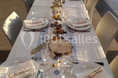 Champ de vignes baigné par la lumière dorée d'un coucher de soleil, avec des arbres et des bâtiments en arrière-plan.