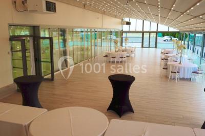 Vue aérienne d'une table élégante décorée de fleurs blanches avec des chaises dorées et un sol en marbre clair.