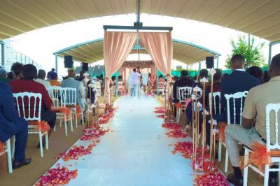 Vue aérienne d'une table élégante décorée de fleurs blanches avec des chaises dorées et un sol en marbre clair.