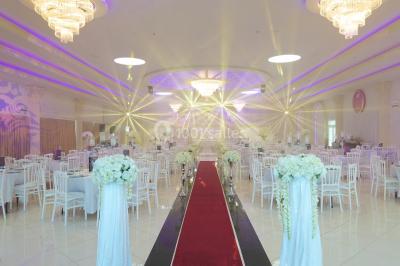 Vue aérienne d'une table élégante décorée de fleurs blanches avec des chaises dorées et un sol en marbre clair.