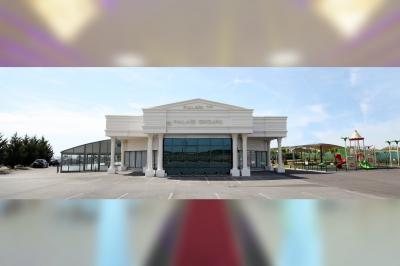 Vue aérienne d'une table élégante décorée de fleurs blanches avec des chaises dorées et un sol en marbre clair.