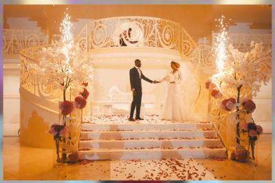 Vue aérienne d'une table élégante décorée de fleurs blanches avec des chaises dorées et un sol en marbre clair.